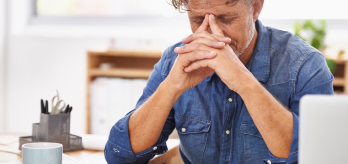 Male hold head in hands from stress